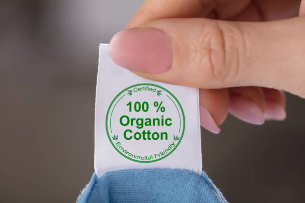 person holding label showing 100 percent organic cotton - 100 percent fotos imagens e fotografias de stock