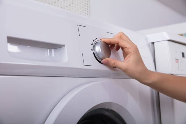 istock Woman Turning Button Of Washing Machine 949191018