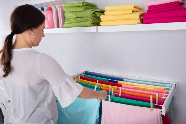 istock Woman Hanging Wet Clothes In Laundry Room 949191074