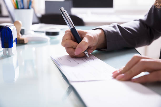 istock Businessperson Signing Cheque In Office 949195298