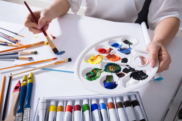 istock Artist Holding Paint Palette While Painting On Canvas Paper 949195744