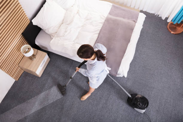 istock Female Janitor Cleaning Carpet With Vacuum Cleaner 949196010