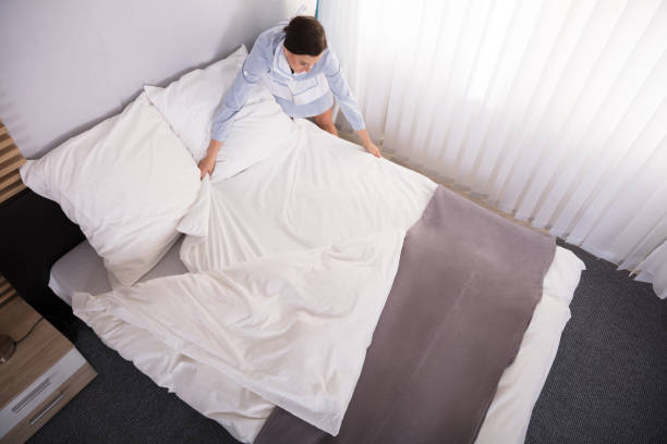 istock Elevated View Of Housekeeper Arranging Bed 949196070