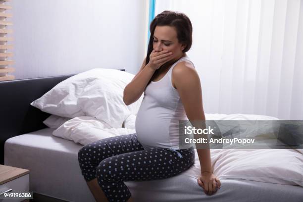 Pregnant Woman Sitting On Bed Stock Photo - Download Image Now - Abdomen, Adult, Adults Only
