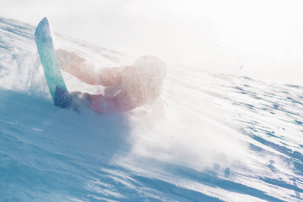 istock snowboarder is riding from snow hill and fall down 949198972