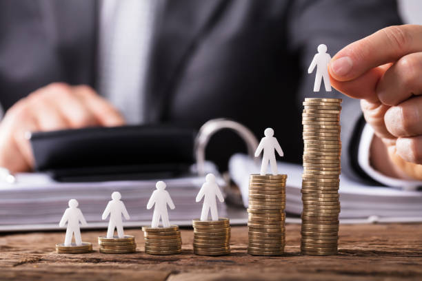 istock Human Hand Placing Human Figure On Increasing Stacked Coins 949199170
