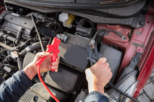 istock Person Using Jumper Cables To Charge Car's Dead Battery 949199646