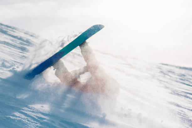 istock snowboarder is riding from snow hill and fall down 949202452