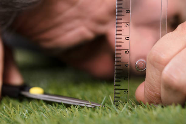 man using measuring scale while cutting grass - obsessive imagens e fotografias de stock