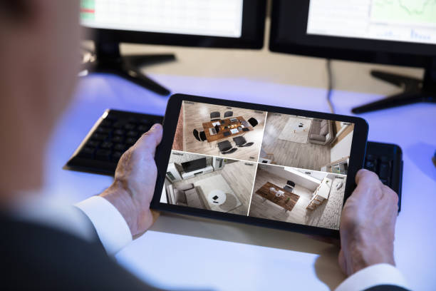 istock Businessman Looking At CCTV Camera Footage On Digital Tablet 949205472