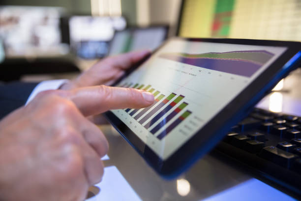 businessperson looking at financial graph on digital tablet - growth plan graph digital tablet imagens e fotografias de stock