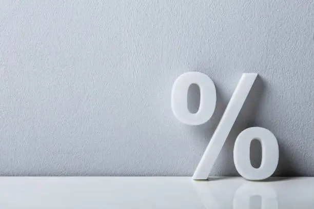 Close-up Of A Percentage Sign Leaning On White Wall