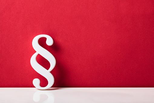 Close-up Of A Paragraph Symbol Leaning On Red Wall