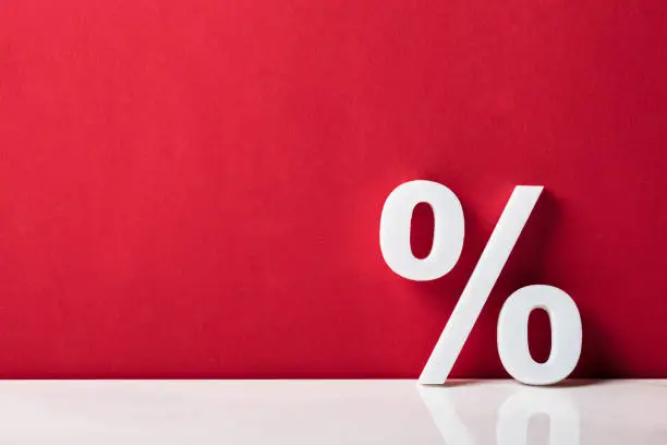 Close-up Of A Percentage Sign Leaning On Red Wall