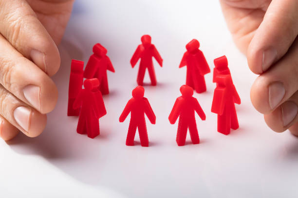 istock Close-up Of A Human Hand Protecting Human Figures 949208392