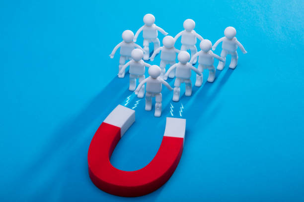 istock Elevated View Of Horseshoe Magnet Attracting Human Figures 949211342