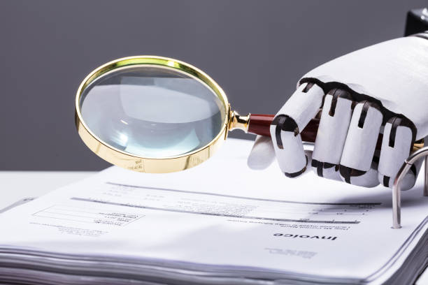 istock Robot Holding Magnifying Glass Over Invoice 949211834