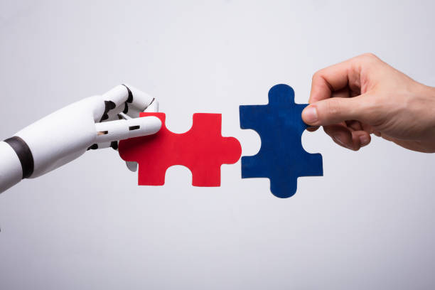 istock Robot And Human Hand Holding Jigsaw Puzzle 949212044