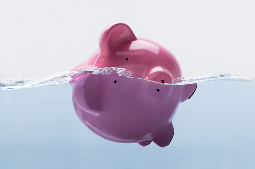 Close-up Of A Pink Piggy Bank Drowning In Water