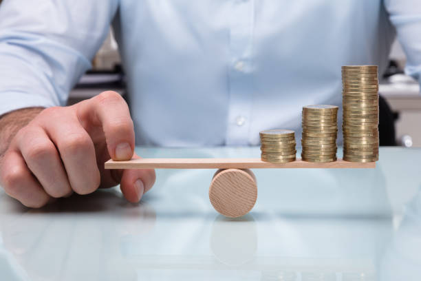 istock Businessperson Balancing Increasing Stacked Coins With Finger 949215086