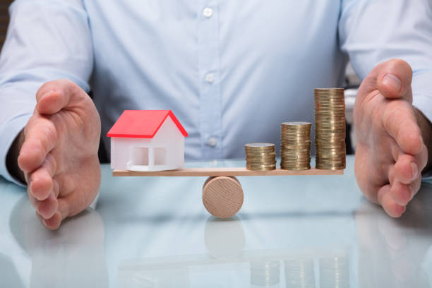 istock Protecting Balance Between House Model And Stacked Coins 949215102