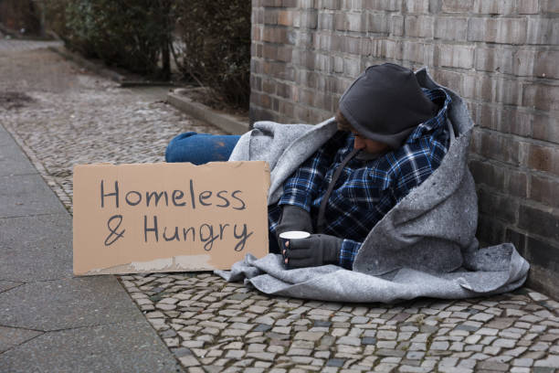 istock Male Beggar Lying On Street 949215838