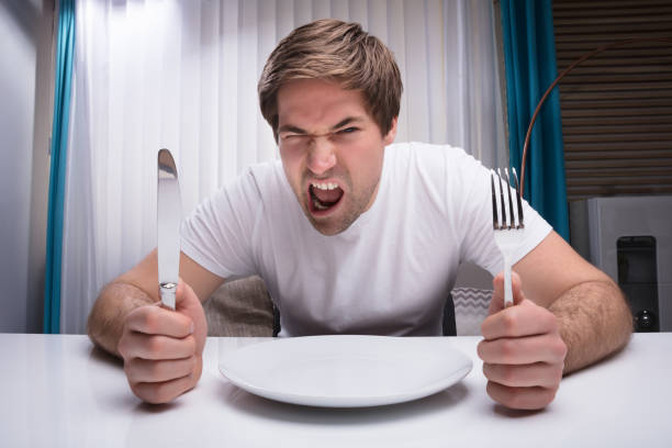 istock Angry Man Holding Knife And Fork 949216226