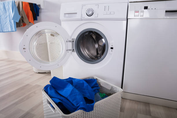 istock Empty Washing Machine With Pile Of Dirty Clothes 949216640