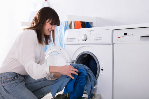 istock Woman Putting Dirty Cloth Into Washing Machine 949216672