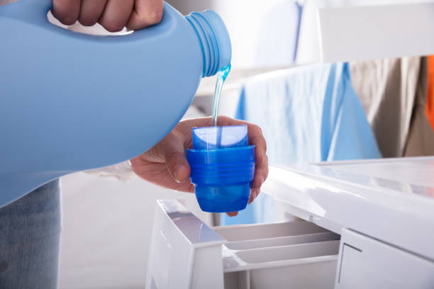 Person Pouring Detergent In Lid Close-up Of A Person's Hand Pouring Detergent In Lid laundry detergent stock pictures, royalty-free photos & images