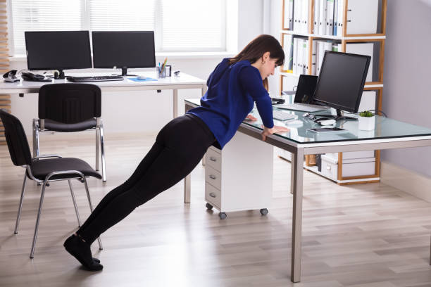 istock Businesswoman Doing Push Up On Office Desk 949219164