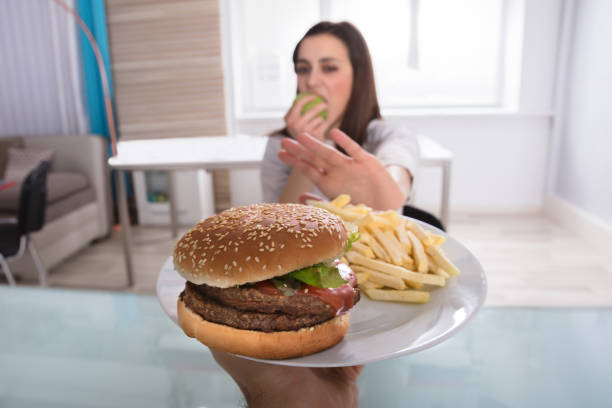 istock Woman Refusing Unhealthy Food While Eating Fruit 949219492