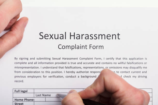 istock Human Hand Filling Sexual Harassment Complaint Form 949219632