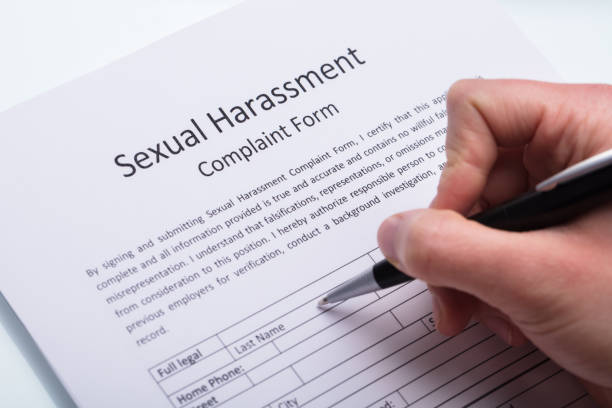 istock Human Hand Filling Sexual Harassment Complaint Form 949219642