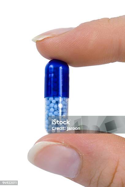 Capsule Between Two Fingers Stock Photo - Download Image Now - Birth Control Pill, Blue, Capsule - Medicine
