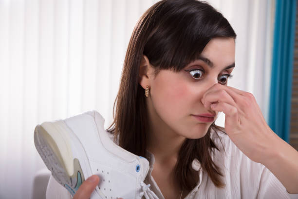 istock Woman Holding Stinky Shoe 949220214