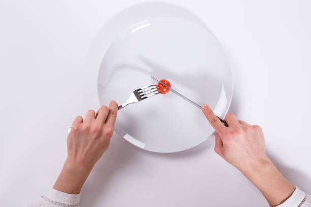 istock Person Cutting Cherry Tomato On Plate 949220262
