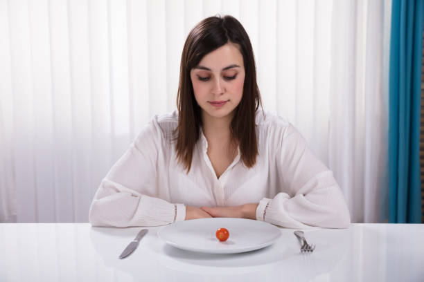 istock Woman Sitting With Plate Of Cherry Tomato 949220268