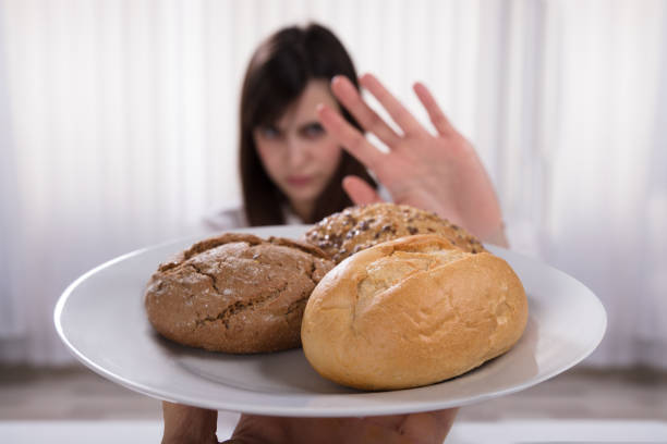istock Woman Refusing Plate Of Bread And Cookies 949220320