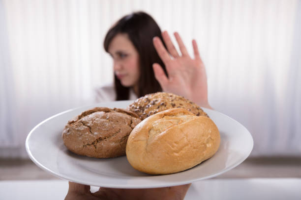 istock Woman Refusing Plate Of Bread And Cookies 949220356