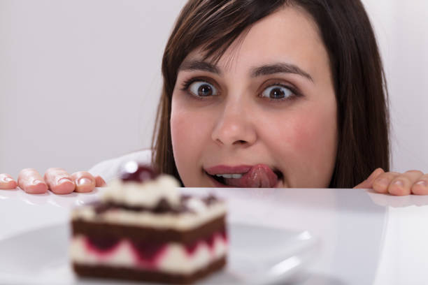 istock Young Woman Looking At Slice Of Cake 949220370