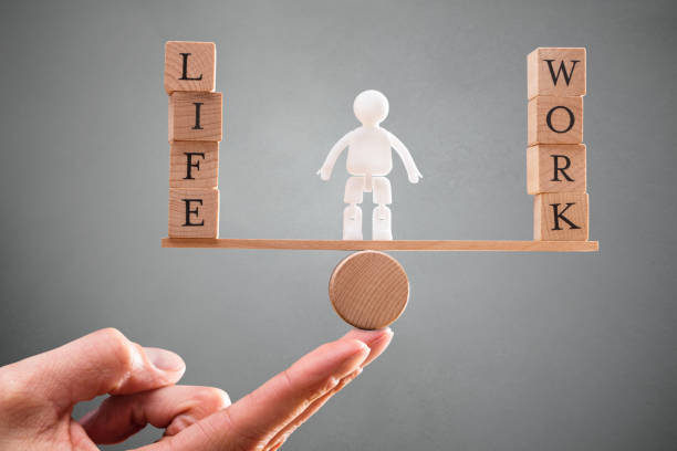 istock Person's Hand With Work And Life Wooden Blocks On Seesaw 949220898