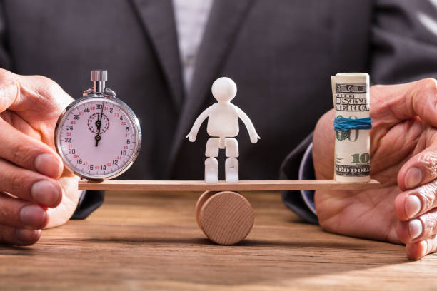 istock Businessperson Balancing Stopwatch And Banknotes 949220918
