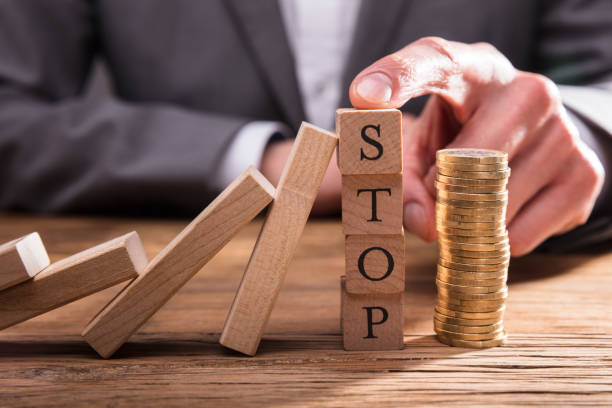 istock Human Finger Stopping Dominos From Falling 949223062