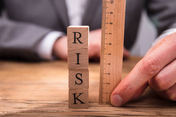istock Businessperson Measuring Risk Wooden Blocks 949223082