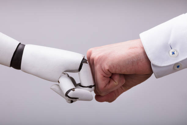 roboter und menschliche hand machen fist bump - roboter stock-fotos und bilder