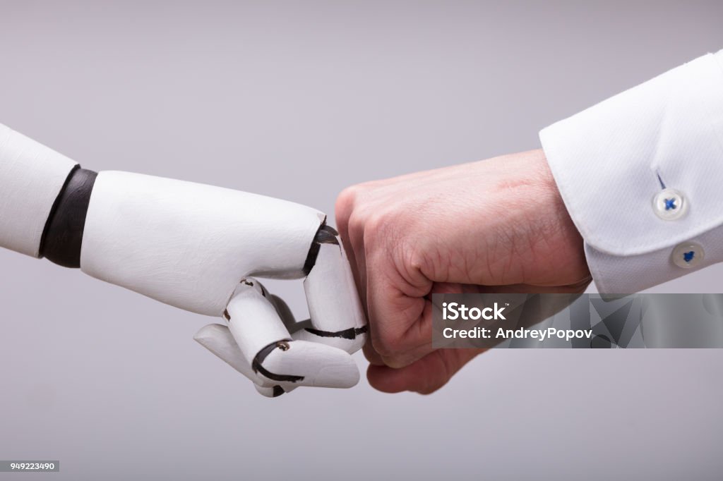 Robot And Human Hand Making Fist Bump Robot And Human Hand Making Fist Bump On Grey Background Robot Stock Photo