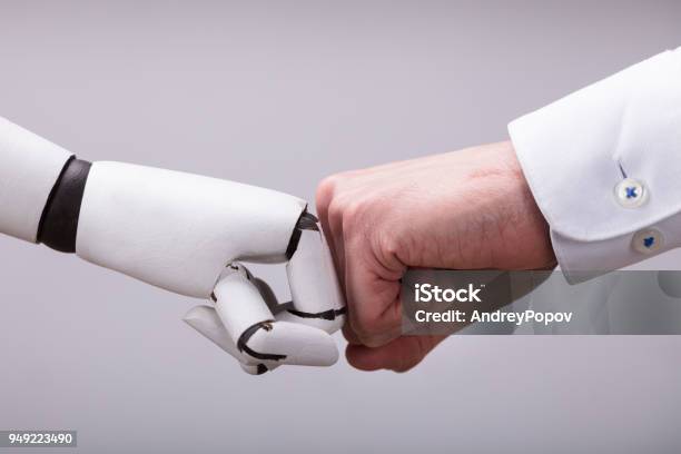 Robot And Human Hand Making Fist Bump Stock Photo - Download Image Now - Robot, People, Machinery