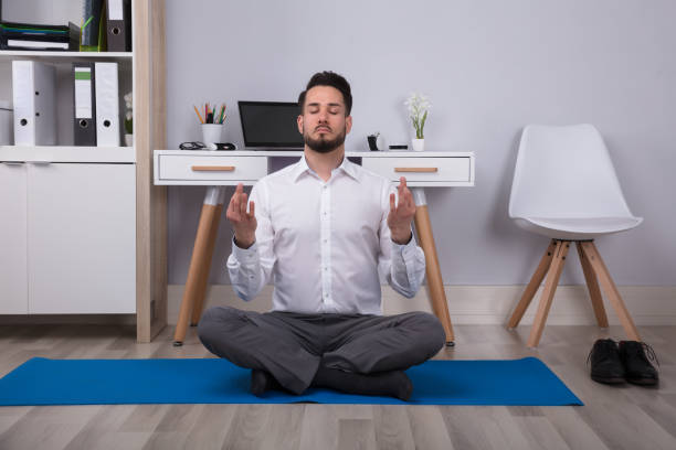 istock Calm Young Businessman Meditating In Office 949223632