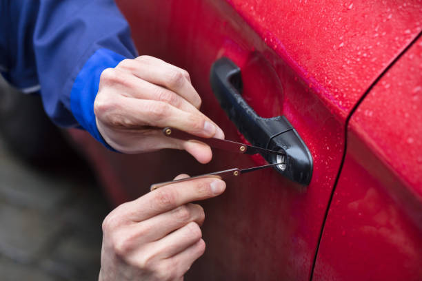 istock Person Opening Car Door With Lockpicker 949224554